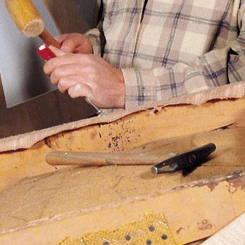 artisan tapissier tenant un marteau